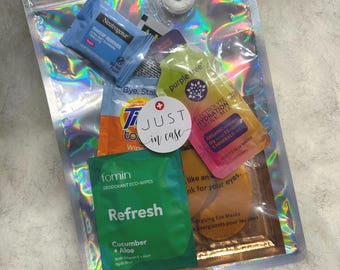 Puede incluir: Una bolsa transparente holográfica con cremallera que contiene varios artículos de aseo de viaje. Incluye toallitas desmaquillantes Neutrogena, mezcla para bebidas electrolíticas, mascarillas para ojos, toallitas desodorantes y una pegatina que dice "Just in case."