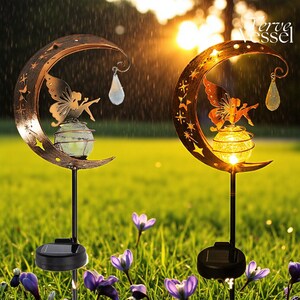 Solar moon fairy garden light with crackle glass globe and warm LED glow, eco-friendly outdoor stake lamp powered by solar panel, durable iron frame with waterproof IP65 design, 800mAh rechargeable battery for 10–12 hours of light, height 84 cm and width 16 cm, perfect for garden pathways, patios, balconies, or yard decoration, whimsical moon fairy design adds charm to outdoor spaces, energy-saving solar garden decor, great gift for garden lovers, birthdays, or housewarmings.
