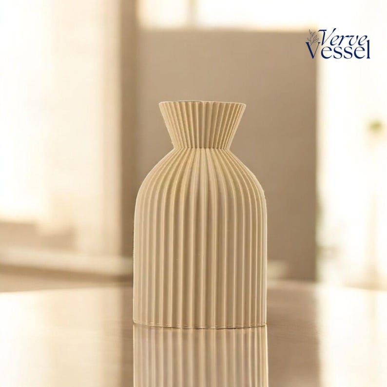 May include: A cream-coloured ceramic vase with a ribbed design. The vase has a narrow neck and a wide base. It is a simple and elegant design.