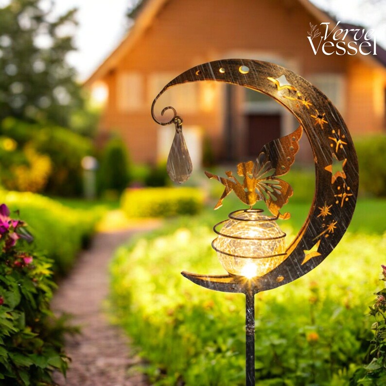 Solar moon fairy garden light with crackle glass globe and warm LED glow, eco-friendly outdoor stake lamp powered by solar panel, durable iron frame with waterproof IP65 design, 800mAh rechargeable battery for 10–12 hours of light, height 84 cm and width 16 cm, perfect for garden pathways, patios, balconies, or yard decoration, whimsical moon fairy design adds charm to outdoor spaces, energy-saving solar garden decor, great gift for garden lovers, birthdays, or housewarmings.