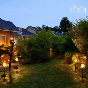 Solar moon fairy garden light with crackle glass globe and warm LED glow, eco-friendly outdoor stake lamp powered by solar panel, durable iron frame with waterproof IP65 design, 800mAh rechargeable battery for 10–12 hours of light, height 84 cm and width 16 cm, perfect for garden pathways, patios, balconies, or yard decoration, whimsical moon fairy design adds charm to outdoor spaces, energy-saving solar garden decor, great gift for garden lovers, birthdays, or housewarmings.