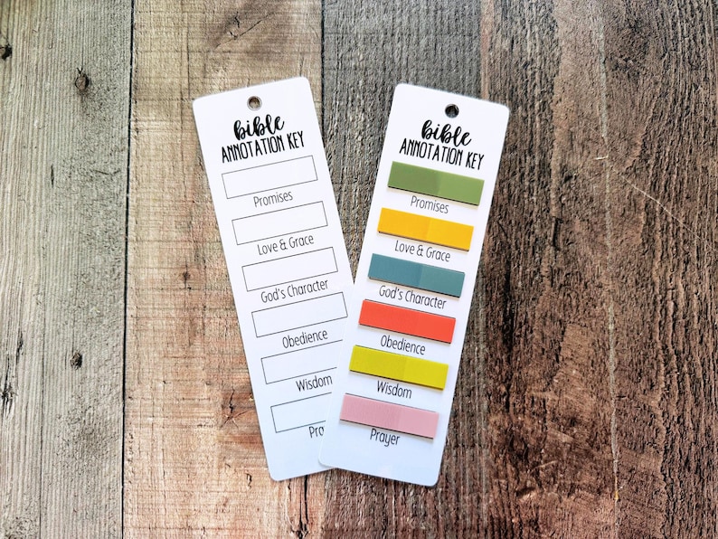 May include: Two white rectangular bookmarks labeled Bible Annotation Key with black text. One bookmark is blank, while the other features six colorful adhesive tabs aligned with categories including Promises, Love & Grace, God's Character, Obedience, Wisdom, and Prayer.