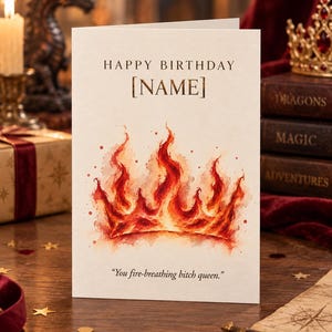 May include: A white greeting card featuring the text HAPPY BIRTHDAY [NAME] at the top and a watercolour illustration of a crown made of orange and red flames in the centre, with the text You fire-breathing bitch queen. printed at the bottom.