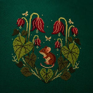 May include: A cross-stitch embroidery on dark green fabric featuring a central brown mouse surrounded by red bell-shaped flowers, green heart-shaped leaves, and small yellow butterflies. The design is arranged in a symmetrical, circular pattern.