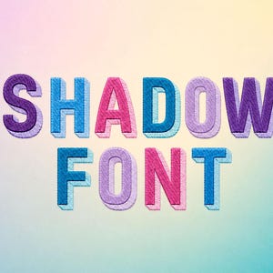 May include: The text SHADOW FONT is displayed in a bold, blocky typeface with a three-dimensional effect. Each letter features a distinct color palette including shades of purple, blue, and pink, with a subtle drop shadow creating depth.