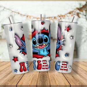 K&ouml;nnte beinhalten: Drei wei&szlig;e isolierte Becher mit einem Cartoon-Charakter-Design. Das Design zeigt einen blauen Au&szlig;erirdischen mit gro&szlig;en Augen und einem rot-blauen Farbschema. Das Wort "AMERICA" ist in Rot, Wei&szlig; und Blau auf die Becher gedruckt.