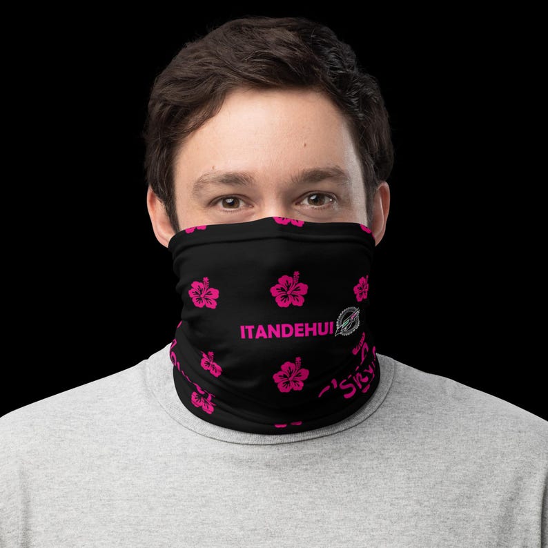 May include: A black neck gaiter featuring a repeating pattern of bright pink hibiscus flowers. The text ITANDEHUI is printed in pink on the front, accompanied by a small circular logo and additional partial pink text near the bottom edge.
