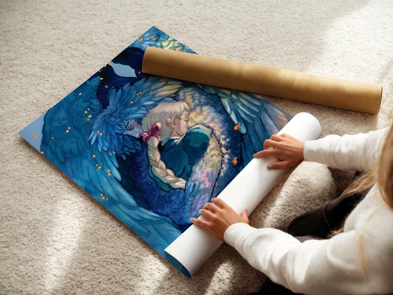 May include: A vibrant art print featuring a couple embracing, surrounded by blue feathered wings. The artwork is on a square canvas, with a rolled-up poster tube beside it. The print is on a light-colored carpet.