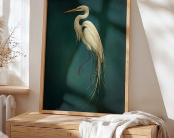 May include: A framed art print featuring a white egret with long, flowing tail feathers. The bird is set against a teal background, with a wooden frame. The artwork is displayed on a wooden dresser.