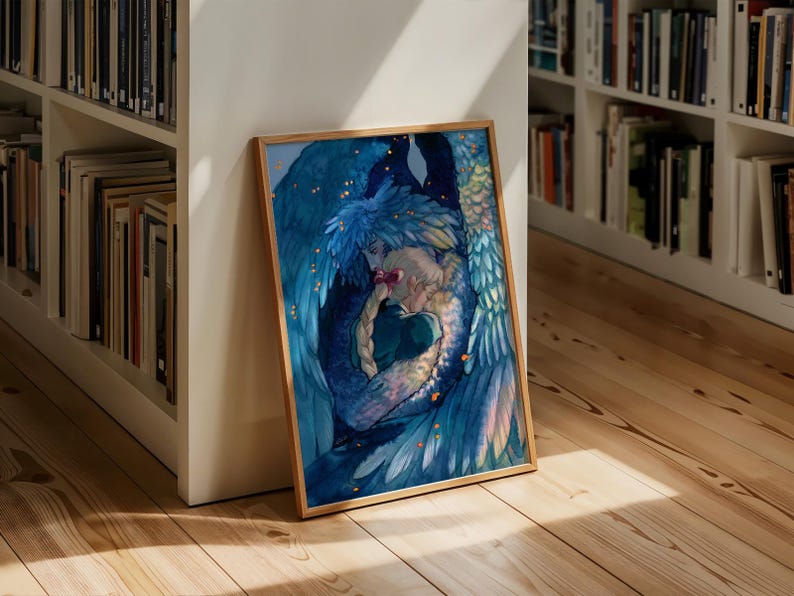 May include: A framed art print featuring a watercolor illustration of two figures embracing, surrounded by blue and teal feathered wings. The artwork has a celestial theme with gold accents and is displayed on a wooden floor.