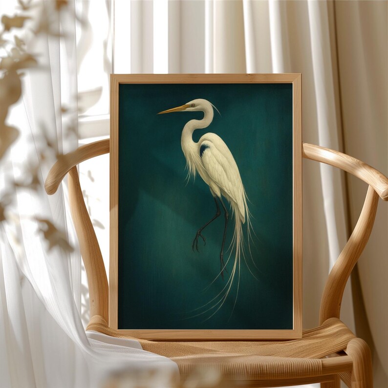 May include: A framed art print featuring a white egret against a teal background. The bird is depicted with detailed feathers and long, elegant tail plumes. The artwork is displayed in a light-colored wooden frame, creating a classic aesthetic.