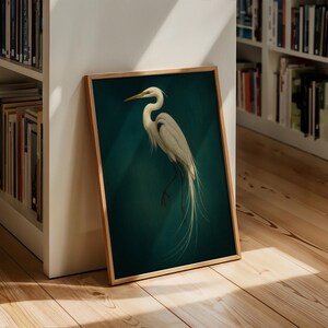 May include: Framed art print featuring a white egret against a teal background. The bird is depicted with detailed feathers and a long, elegant neck. The artwork is encased in a wooden frame, adding a touch of natural warmth to the piece.