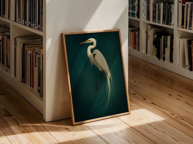 May include: Framed art print featuring a white egret against a teal background. The bird is depicted with detailed feathers and a long, elegant neck. The artwork is encased in a wooden frame, adding a touch of natural warmth to the piece.