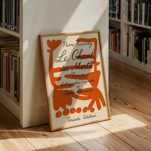 May include: A framed poster with an orange abstract design and the text "Pierre Reverdy Le Chant des Morts Poemes Lithographies originales de Pablo Picasso  Triaide Editeur".