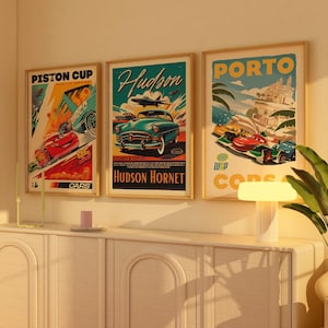 Op de afbeelding: Drie vintage-achtige posters met een race-thema. De posters tonen illustraties van auto's en de tekst "Piston Cup Cars", "Hudson Hornet" en "Porto Corsa".