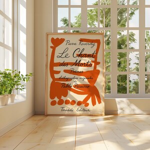 May include: A vintage book cover with an orange abstract design and the text "Pierre Reverdy Le Chant des Morts Poemes Lithographies originales de Pablo Picasso  Teriade Editeur".