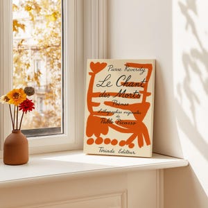 May include: A book titled "Le Chant des Morts" by Pierre Reverdy with original lithographs by Pablo Picasso. The cover features an abstract orange and white design.