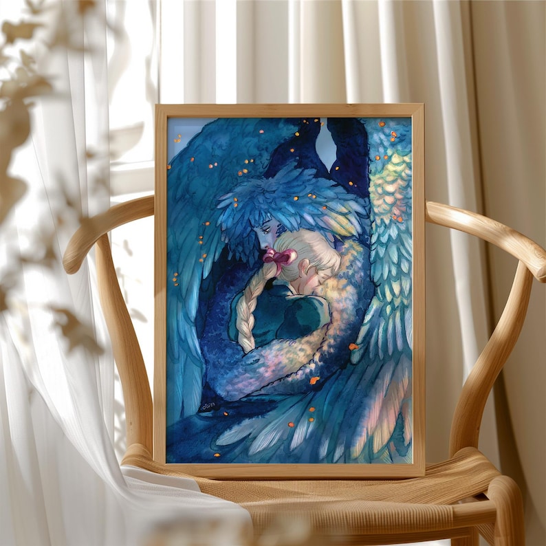 May include: A framed art print featuring a watercolor illustration of two figures embracing, surrounded by blue feathered wings. The artwork has a warm, inviting feel, with soft colors and a focus on the figures' connection. The frame is made of light-colored wood.