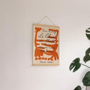 May include: A beige canvas print with an orange abstract design and black text. The text reads "Pierre Reverdy Le Chant des Morts Poemes Lithographies originales de Pablo Picasso  Teriade Editeur".