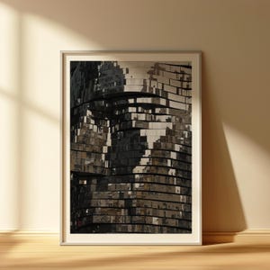 May include: Framed art print featuring a close-up of a modern architectural structure. The artwork showcases a layered design with reflective, dark gray and silver panels, creating a textured, abstract effect. The print is displayed in a white frame.