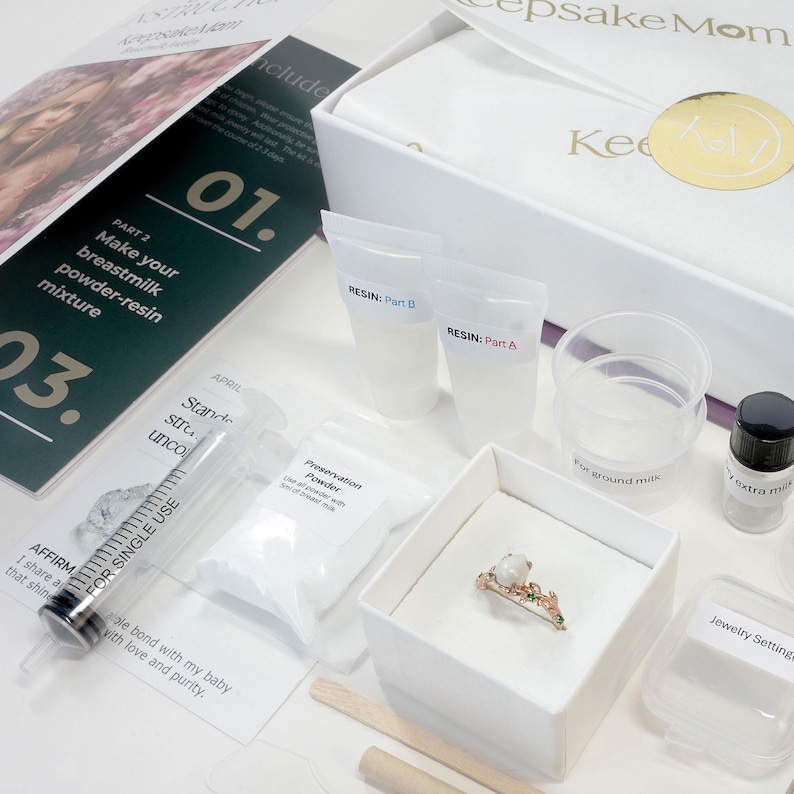 breastmilk jewelry DIY kit box with instructions, measuring and mixing tools, resin and syringe and ring in a ring box outside of the purple diy kit box for breastmilk jewelry keepsakes from KeepsakeMom