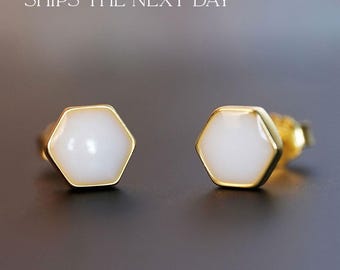 Puede incluir: Un par de pendientes de botón hexagonales de oro con inserciones de esmalte blanco.