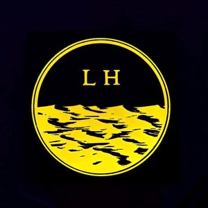 May include: A circular graphic with a black upper half and a yellow lower half depicting a stylized landscape. The letters "LH" are in yellow at the top. The design is set against a dark background.