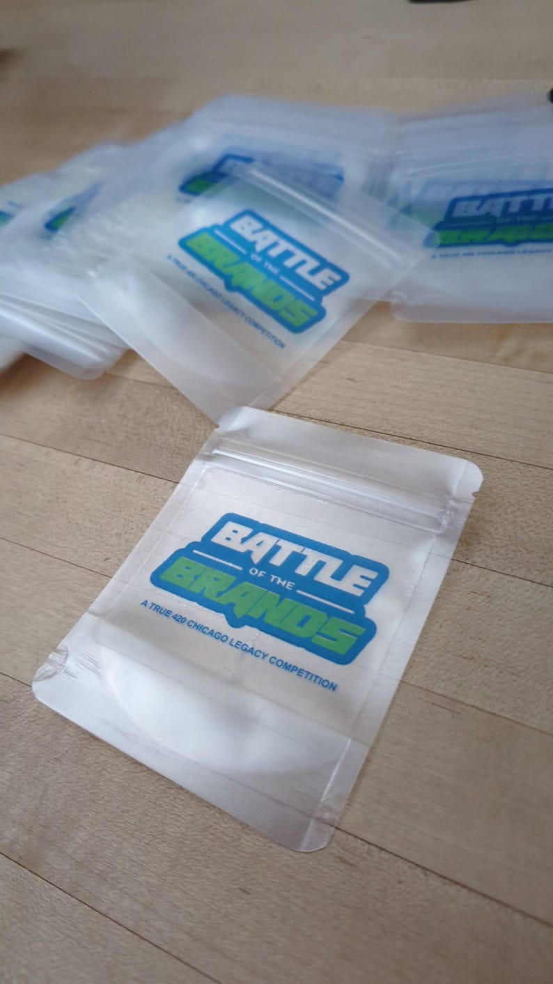 May include: Clear plastic bags with a zip closure, featuring a blue and green logo that reads "BATTLE OF THE BRANDS" and the text "A TRUE 420 CHICAGO LEGACY COMPETITION". Several bags are visible, some overlapping.