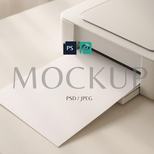 May include: A white printer with a sheet of white paper emerging from the output tray. The word "MOCKUP" is printed in gray on the paper, along with "PSD / JPEG". Logos for "PS" and a swirl are also visible.