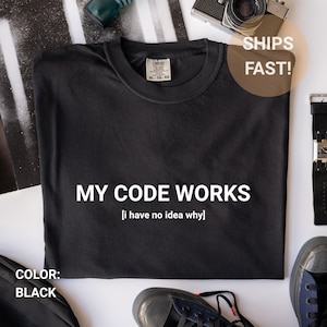 Könnte beinhalten: Schwarzes T-Shirt mit dem weißen Text "MY CODE WORKS [i have no idea why]". Das T-Shirt hat einen Rundhalsausschnitt und ein Etikett "COMFORT COLORS". Größe XL-TG-EG.