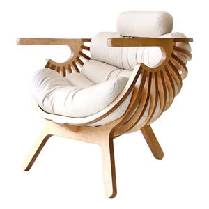 May include: A contemporary armchair with a light wood frame and cream cushions. The chair has a distinctive design with curved wooden slats and armrests, and a headrest. The chair is designed for comfort and style, and is a statement piece.