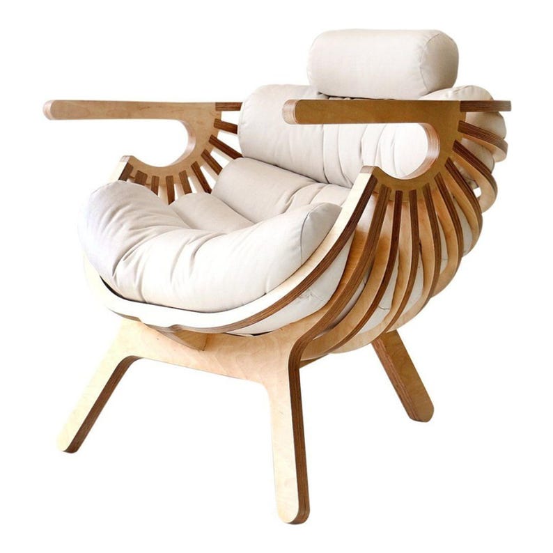 May include: A contemporary armchair with a light wood frame and cream cushions. The chair has a distinctive design with curved wooden slats and armrests, and a headrest. The chair is designed for comfort and style, and is a statement piece.