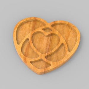 May include: Wooden heart-shaped serving tray with a nested heart design. The tray is made of light-coloured wood and features a carved-out heart shape in the centre, surrounded by a larger heart outline. Ideal for serving snacks or as a decorative piece.