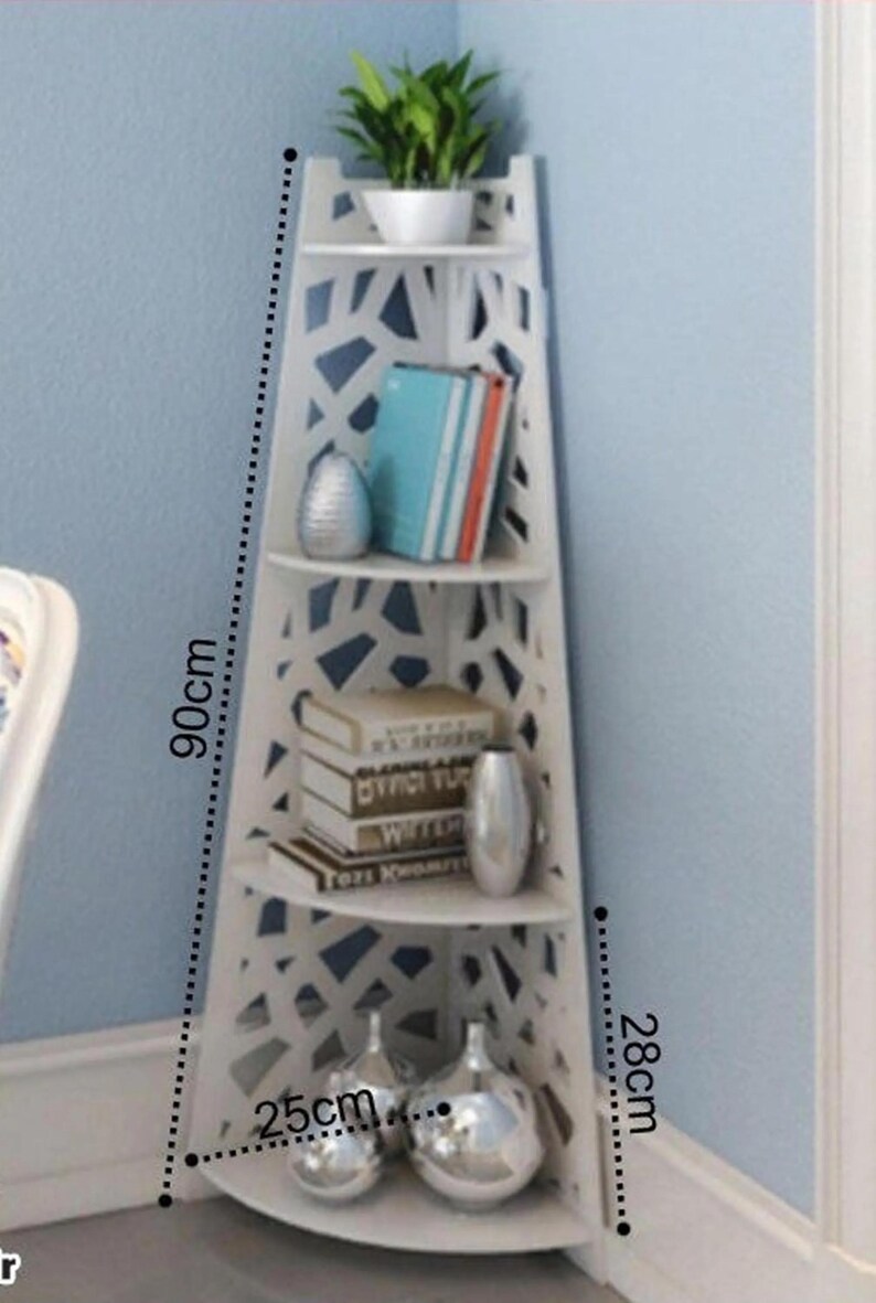 May include: White corner shelf unit with 4 shelves. The shelf is 90 inches tall, 28 inches wide, and 25 inches deep. The shelves have a decorative cut-out design and are perfect for displaying books, plants, and decorative items.