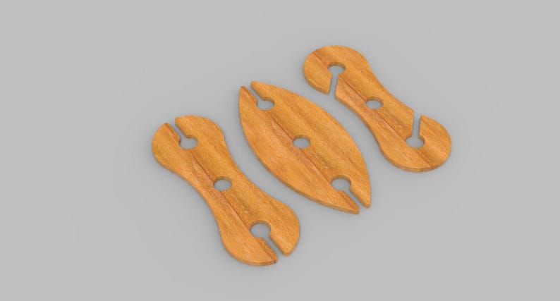 May include: Three wooden wine glass holders in a light brown color. Each holder has a unique shape with a circular hole and a slot for the stem of a wine glass. The holders are arranged on a gray surface.