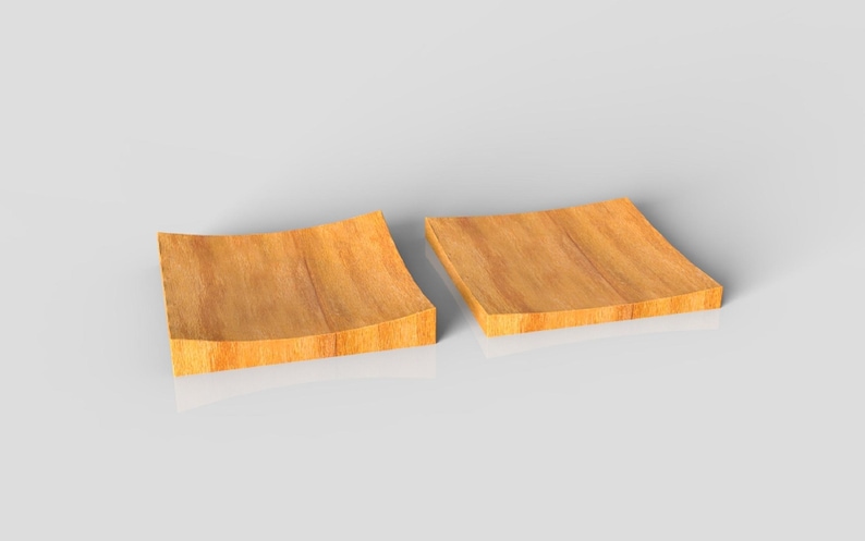 K&ouml;nnte beinhalten: Zwei quadratische Holzplatten mit geschwungenem Design. Die Platten bestehen aus hellbraunem Holz mit sichtbarer Maserung und einem leicht erh&ouml;hten Rand. Die Platten werden auf einer wei&szlig;en Oberfl&auml;che pr&auml;sentiert.