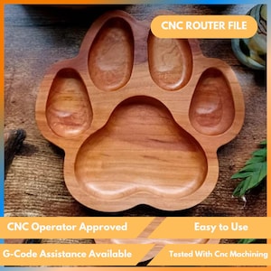 Puede incluir: Una bandeja de madera con forma de pata con cinco compartimentos. La bandeja es de madera de color marrón claro y tiene un acabado liso. El texto "CNC ROUTER FILE" es visible. La bandeja está diseñada para mecanizado CNC.