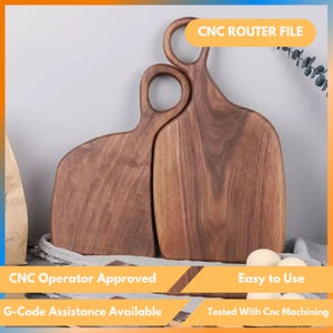 Pode incluir: Duas tábuas de corte de madeira com alças. As tábuas são de cor castanho escuro e têm um acabamento liso. As alças têm uma abertura circular. O texto na imagem diz "CNC ROUTER FILE", "CNC Operator Approved", "Easy to Use", "G-Code Assistance Available" e "Tested With Cnc Machining."