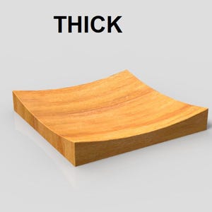K&ouml;nnte beinhalten: Ein quadratisches Holztablett mit einer gew&ouml;lbten, konkaven Oberfl&auml;che. Das Tablett besteht aus hellbraunem Holz und hat ein dickes, solides Aussehen. Das Wort "THICK" ist in Schwarz &uuml;ber dem Tablett aufgedruckt.