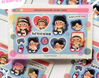 Può includere: Un foglio di adesivi con illustrazioni di cartoni animati di un personaggio con occhiali, cuffie e una tastiera. Gli adesivi hanno uno schema di colori blu, rosa e bianco, con il testo "Wonwoo Game Boi sticker sheet", "Wonwoo" e "baterkookies".