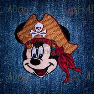May include: Embroidered patch featuring a cartoon mouse wearing a pirate hat with a skull and crossbones. The mouse has a red bandana and a red scarf. The patch is on a blue denim background.