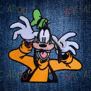 May include: Embroidered patch featuring Goofy, a Disney cartoon character, in a dynamic pose. Goofy is depicted with his signature orange shirt, black ears, and white gloves. The patch is set against a denim background.