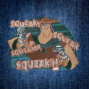 May include: Embroidered patch featuring a cartoon character with two chipmunk-like figures. The patch has the words "Squeaky Squeaker Squeakin" in orange lettering. The patch is on a blue denim background.