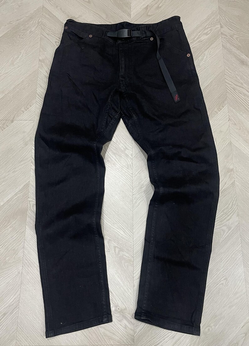 Puede incluir: Pantalones vaqueros negros con cintur&oacute;n negro incorporado. Los pantalones tienen un dise&ntilde;o cl&aacute;sico de cinco bolsillos y un corte de pierna recto. Fabricados en denim duradero, son adecuados para uso casual.