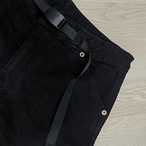 Puede incluir: Pantalones negros con cintur&oacute;n negro incorporado y una peque&ntilde;a etiqueta con el logotipo rojo. Los pantalones tienen un dise&ntilde;o de pierna recta y cuentan con remaches de color cobre. El cintur&oacute;n tiene una hebilla negra. Los pantalones est&aacute;n hechos de tela duradera.