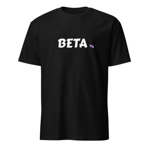 Può includere: T-shirt nera con la scritta "BETA" in bianco, con un carattere stilizzato. Un piccolo disegno colorato si trova a destra della parola. La maglietta ha maniche corte e girocollo.