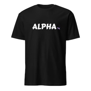 May include: Black t-shirt with the word "ALPHA" in white, stylized font across the chest. A small, colorful design is to the right of the word. The shirt has short sleeves and a crew neck.