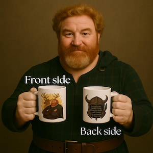 May include: Two white ceramic mugs, one with a cartoon image of a man and deer, the other with a horned helmet graphic and text. The mugs are held up, with the words "Front side" and "Back side" visible.