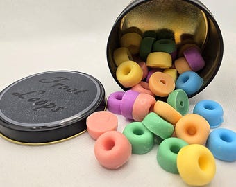 May include: A black tin with a lid and a gold interior, filled with colorful, ring-shaped objects. The lid is labeled "Froot Loops" in white script. The objects are in various colors, including pink, green, yellow, and purple.
