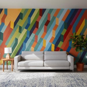 May include: A modern living room featuring a light gray sofa, a wooden side table with a lamp, and a patterned rug. The focal point is a vibrant, colorful geometric mural on the wall, with a potted plant adding a touch of nature.